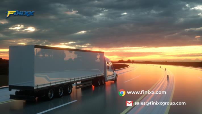 Truck driving on a highway surrounded by green hills, symbolizing the durability and efficiency of TBR and OTR tires by Finixx Tyre.